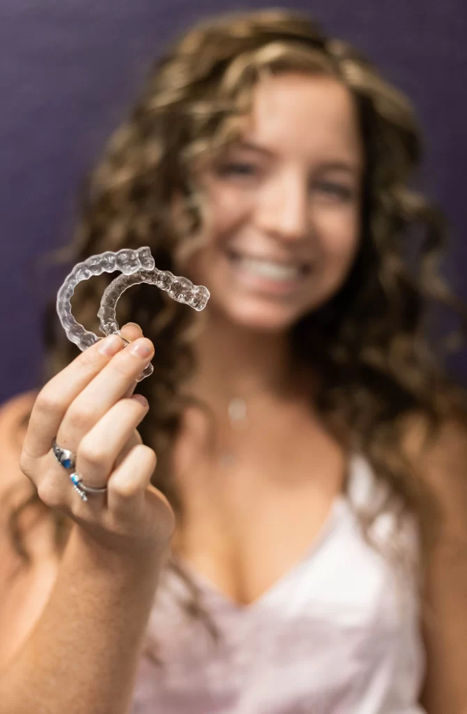 Close up of two invisalign aligners being held in the hand of a woman