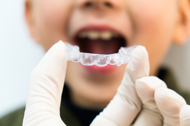 Invisalign being held in front of a chid in in Brevard County, FL