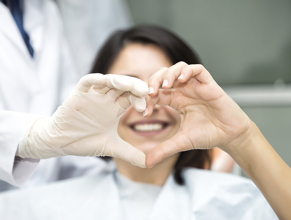 Employee at the Melbourne, FL orthodontic office making a heart with her hands.