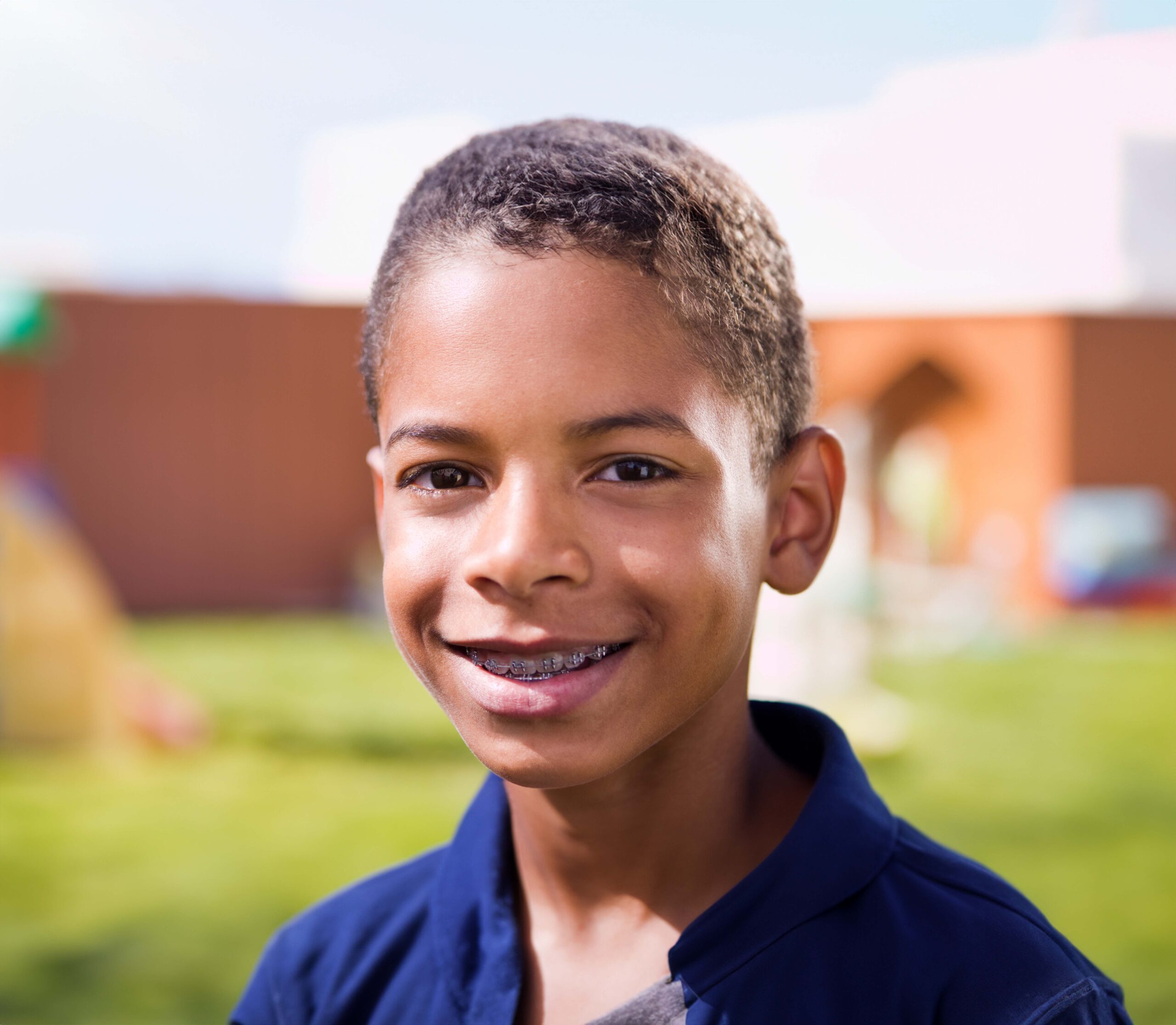 Child receiving phase one orthodontic treatment with braces for kids smiling on a playground